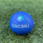 A ZonicBall mini resting on green artificial turf, featuring the white ZONICBALL text and a light blue lightning bolt logo.