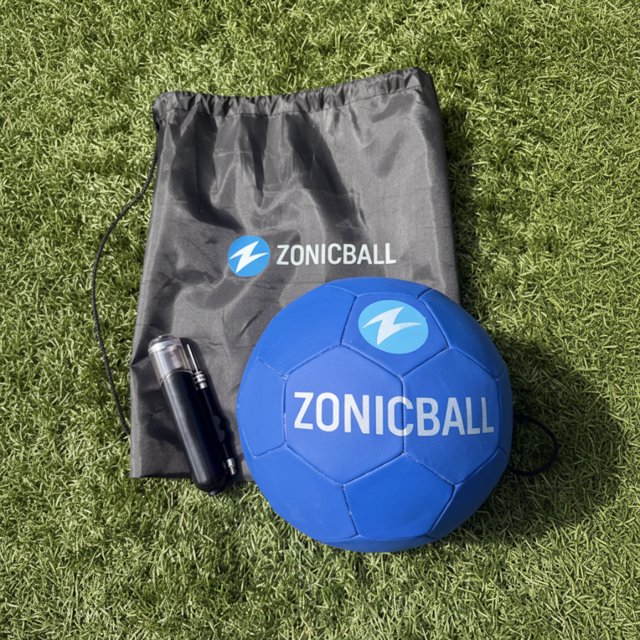 Zonicball soccer ball with white branding, shown next to a black drawstring bag and a black pump on green turf.